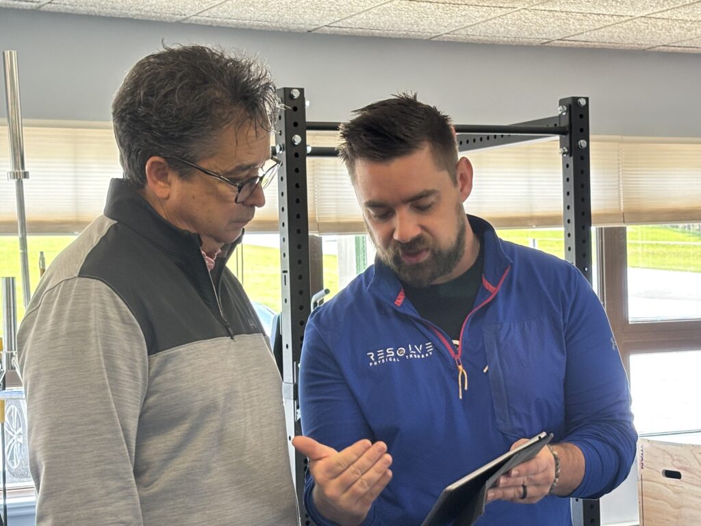 Dr Joe Myhren reviewing golf assessment results with golfer