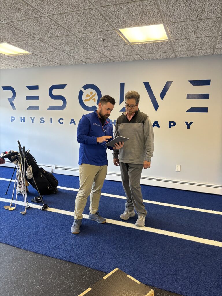 Dr Joe Myhren discussing TPI golf assessment with golfer